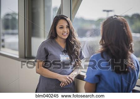 Stock Photography - Nurses talking in hospital hallway. Fotosearch