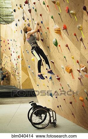 Picture - Paraplegic woman rock climbing in gym. Fotosearch