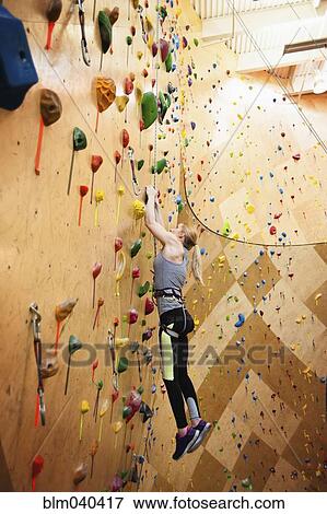 Stock Photo - Paraplegic woman rock climbing in gym. Fotosearch