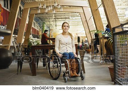 Stock Photo - Paraplegic woman sitting in wheelchair in cafe. Fotosearch