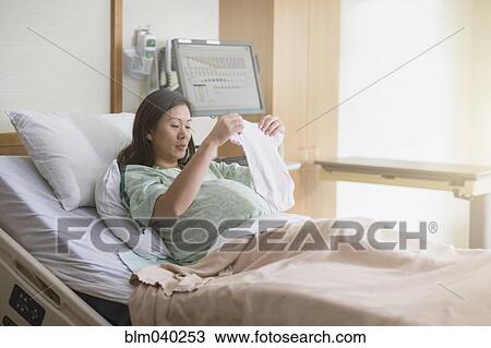 Stock Image - Pregnant Chinese woman in hospital bed. Fotosearch