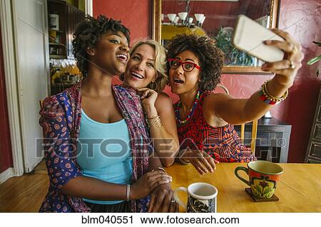 Stock Image - Smiling women taking selfie. Fotosearch