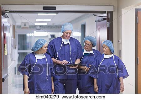 Surgeons using digital tablet in hospital hallway View Large Photo Image Stock Photo - Surgeons using digital tablet in hospital hallway. Fotosearch