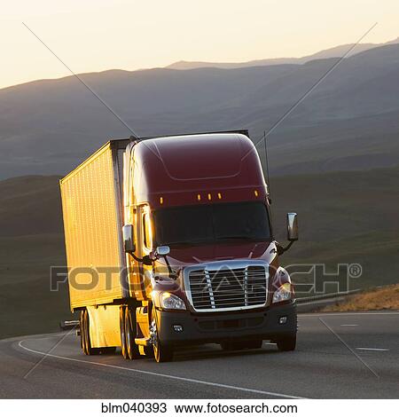Stock Image - Truck driving on remote highway. Fotosearch