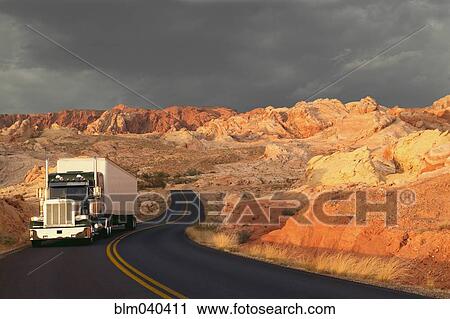 Stock Image - Truck driving on remote highway. Fotosearch