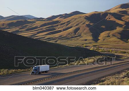 Stock Photo - Truck driving on remote highway. Fotosearch
