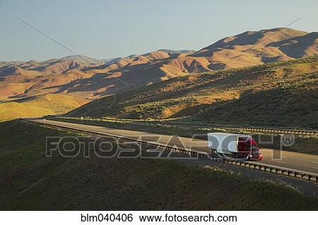 Stock Photograph - Truck driving on remote highway. Fotosearch