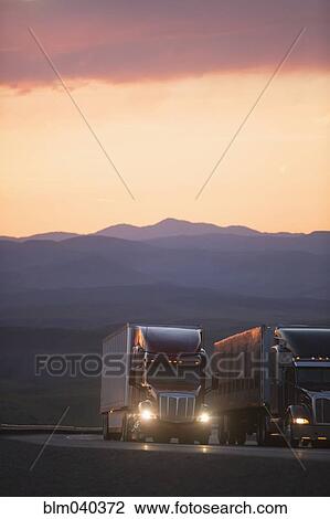 Trucks driving on remote highway View Large Photo Image Stock Image - Trucks driving on remote highway. Fotosearch