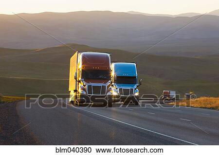 Trucks driving on remote highway View Large Photo Image Stock Image - Trucks driving on remote highway. Fotosearch