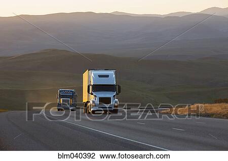 Trucks driving on remote highway View Large Photo Image Stock Image - Trucks driving on remote highway. Fotosearch