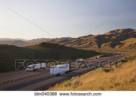 Trucks driving on remote highway View Large Photo Image Stock Photo - Trucks driving on remote highway. Fotosearch