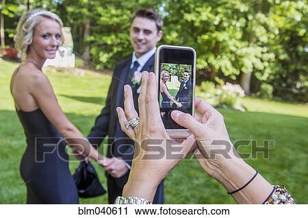 Woman taking cell phone photograph of couple View Large Photo Image Stock Image - Woman taking cell phone photograph of couple. Fotosearch