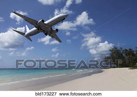 Airplane flying over tropical beach View Large Photo Image Stock Photo - Airplane flying over tropical beach. Fotosearch