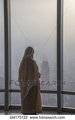 Asian woman at window admiring Dubai cityscape, Dubai Emirate, United Arab Emirates View Large Photo Image Stock Image - Asian woman at window admiring Dubai cityscape, Dubai Emirate, United Arab Emirates. Fotosearch