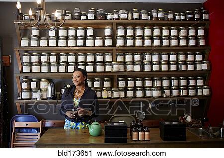 Stock Image - Black woman drinking tea in tea shop. Fotosearch
