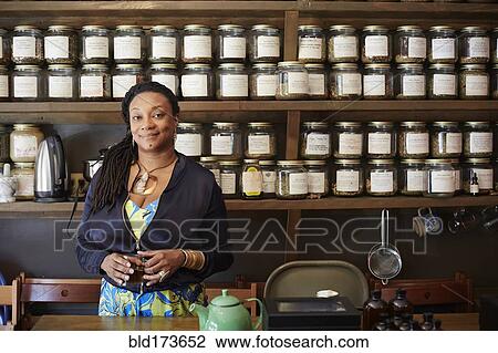 Stock Image - Black woman drinking tea in tea shop. Fotosearch