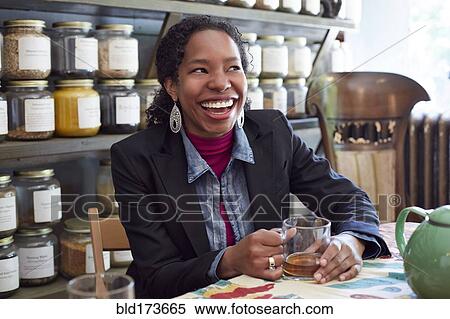 Stock Photography - Black woman drinking tea in tea shop. Fotosearch