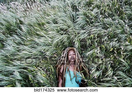Stock Photography - Black woman laying in grass. Fotosearch