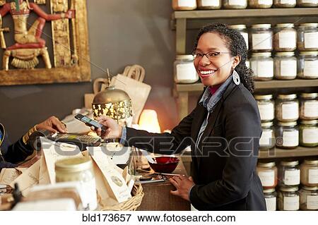Stock Photo - Black woman purchasing tea in tea shop. Fotosearch