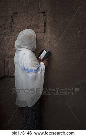 Stock Photograph - Black woman reading at wall. Fotosearch