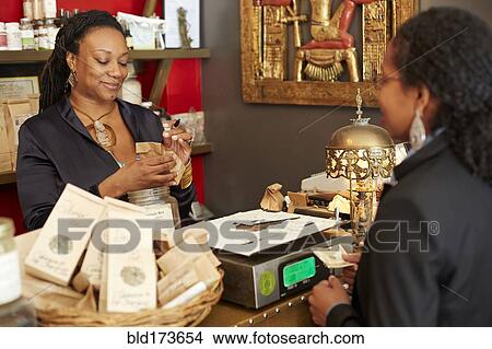 Black woman serving customer in tea shop View Large Photo Image Picture - Black woman serving customer in tea shop. Fotosearch