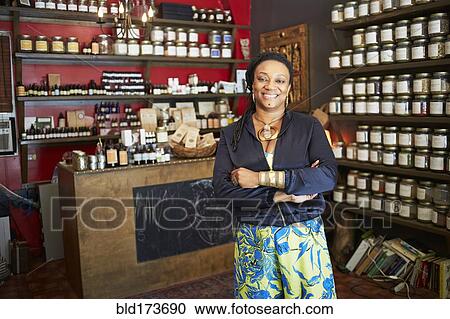 Stock Image - Black woman smiling in tea shop. Fotosearch