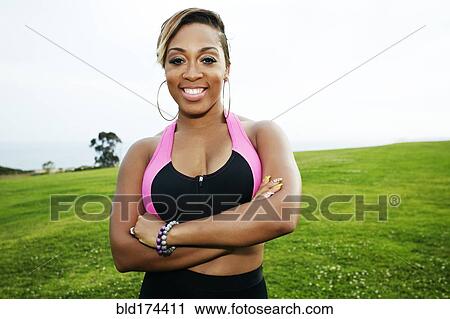 Stock Image - Black woman standing in field. Fotosearch
