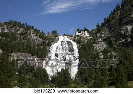 Stock Photo - Building over waterfall on remote hillside. Fotosearch