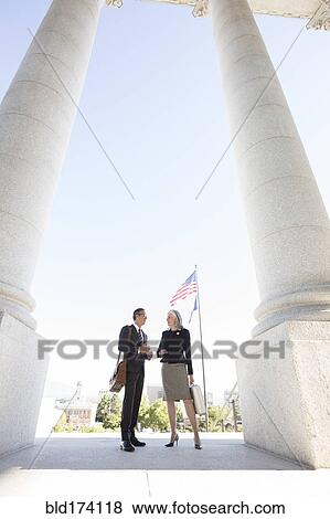 Stock Photo - Business people talking under columns. Fotosearch