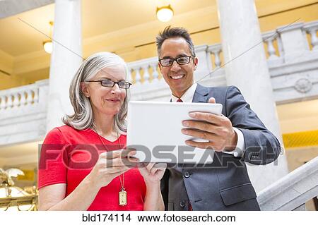 Picture - Business people using digital tablet in courthouse. Fotosearch
