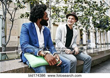 Stock Photograph - Businessmen sitting on stone bench. Fotosearch