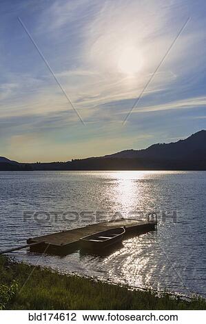 Stock Image - Canoe and wooden dock in remote lake. Fotosearch