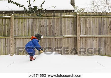 Stock Image - Caucasian boy playing in snow. Fotosearch
