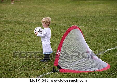 Stock Photography - Caucasian boy playing soccer in field. Fotosearch