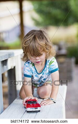 Caucasian boy playing with toy car View Large Photo Image Stock Image - Caucasian boy playing with toy car. Fotosearch