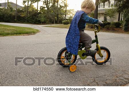 Caucasian boy riding bicycle with training wheels View Large Photo Image Stock Image - Caucasian boy riding bicycle with training wheels. Fotosearch