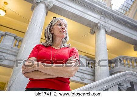 Stock Image - Caucasian businesswoman standing in courthouse. Fotosearch