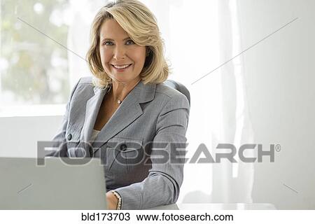 Stock Image - Caucasian businesswoman using laptop. Fotosearch