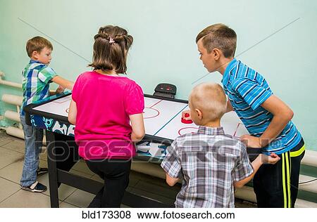 Caucasian children playing air hockey View Large Photo Image Stock Photo - Caucasian children playing air hockey. Fotosearch