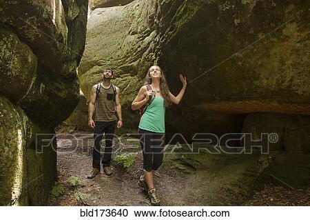 Stock Image - Caucasian couple exploring cave. Fotosearch