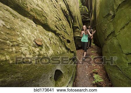 Stock Image - Caucasian couple exploring cave. Fotosearch