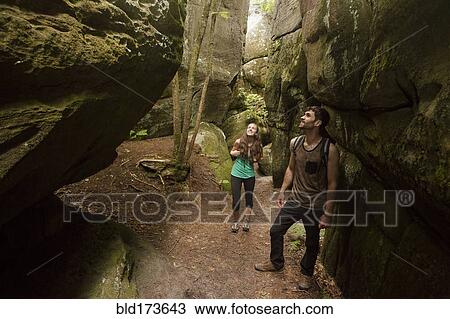 Stock Image - Caucasian couple exploring cave. Fotosearch