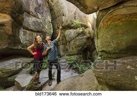 Stock Photograph - Caucasian couple exploring cave. Fotosearch