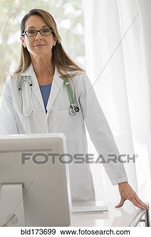 Stock Photo - Caucasian doctor using computer. Fotosearch