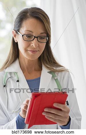 Stock Photo - Caucasian doctor using digital tablet. Fotosearch