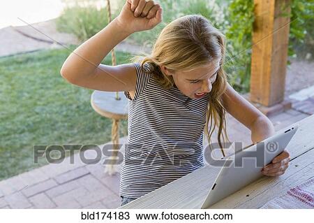 Caucasian girl cheering at digital tablet View Large Photo Image Stock Image - Caucasian girl cheering at digital tablet. Fotosearch