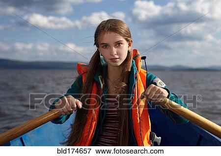 Stock Photo - Caucasian girl rowing canoe in lake. Fotosearch