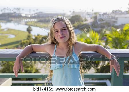 Stock Photography - Caucasian girl standing on balcony. Fotosearch