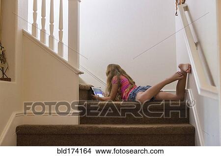 Caucasian girl using digital tablet on stairs View Large Photo Image Picture - Caucasian girl using digital tablet on stairs. Fotosearch