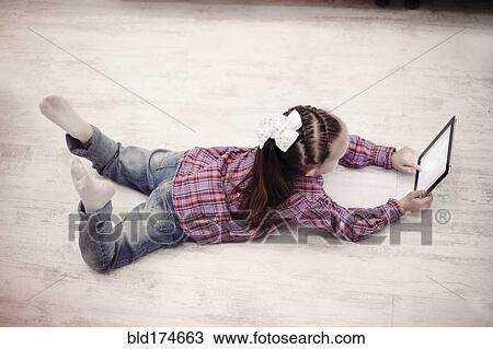 Stock Image - Caucasian girl using digital tablet. Fotosearch
